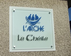 Glass plaque with backing plate to make graphics easily visible against wall